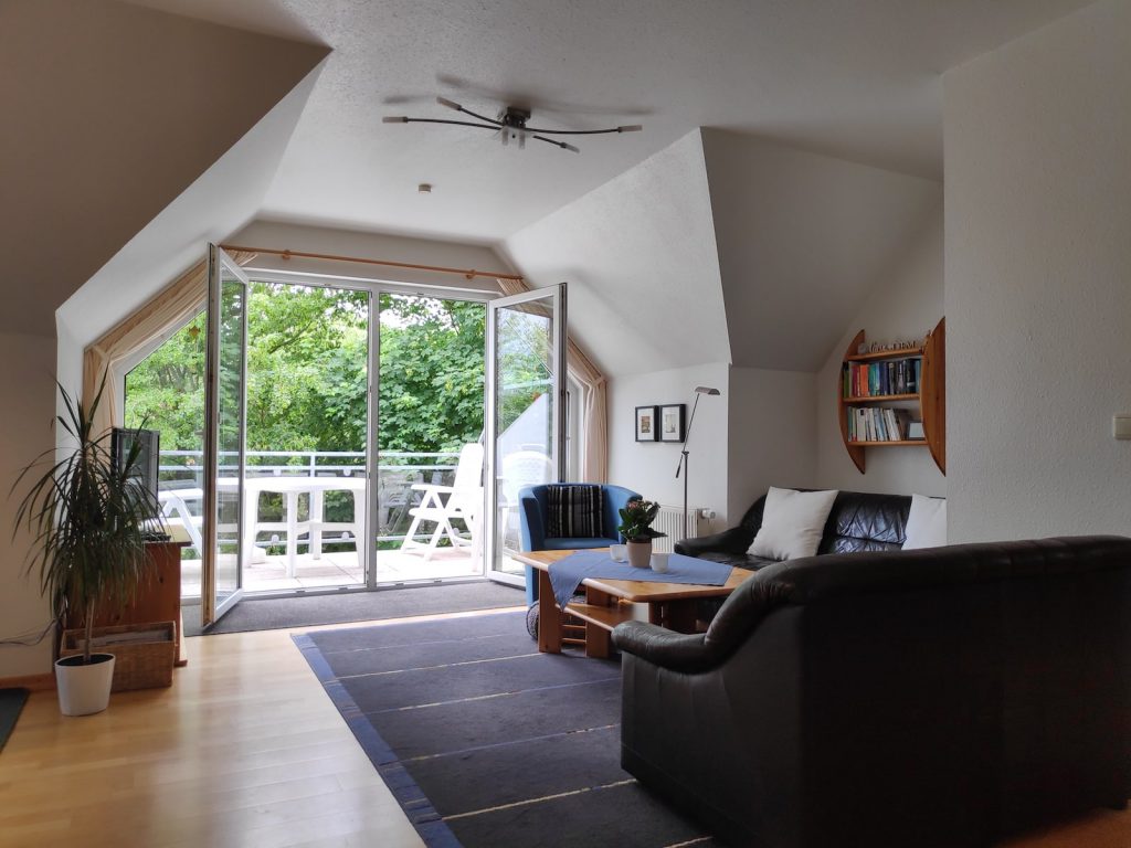 Wohnzimmer mit Balkon - Ferienwohnung Carolinensiel