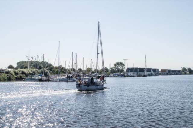 Fahrendes Segelboot im Yachthafen von Harlesiel